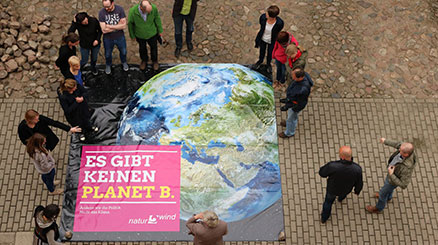 Menschen stehen um Plakat Es gibt keinen Planet B